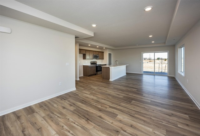 unfurnished living room with dark hardwood / wood-style flooring and sink