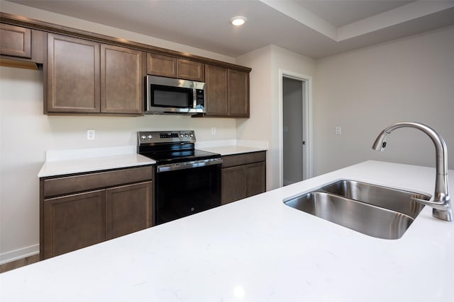 kitchen featuring sink, hardwood / wood-style floors, electric range, and dark brown cabinetry