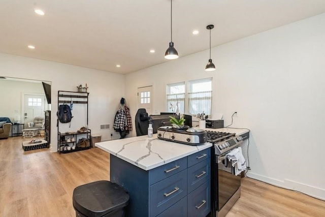 kitchen with stainless steel gas stove, decorative light fixtures, a healthy amount of sunlight, and light wood-type flooring