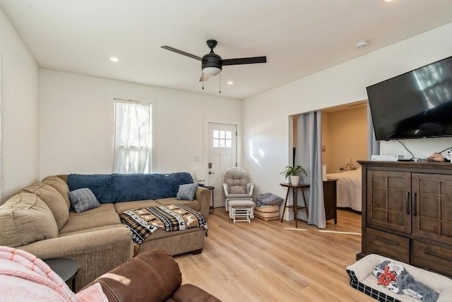 living room with light hardwood / wood-style floors and ceiling fan