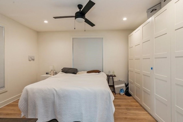 bedroom featuring light hardwood / wood-style floors, ceiling fan, and a closet