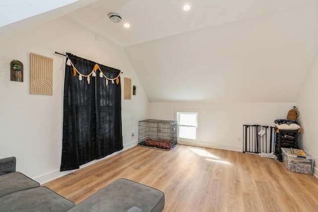 living room featuring vaulted ceiling and light hardwood / wood-style flooring