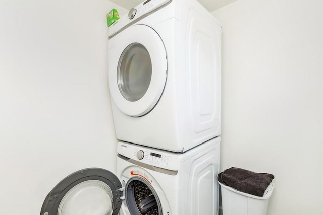 washroom featuring stacked washing maching and dryer