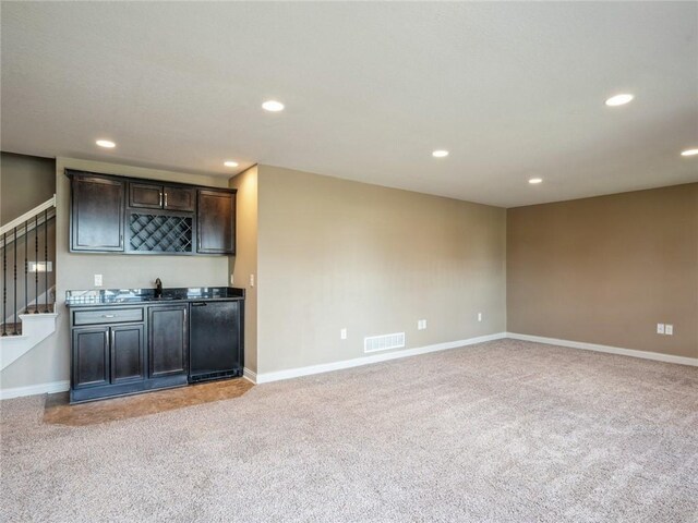 unfurnished living room featuring light colored carpet and sink