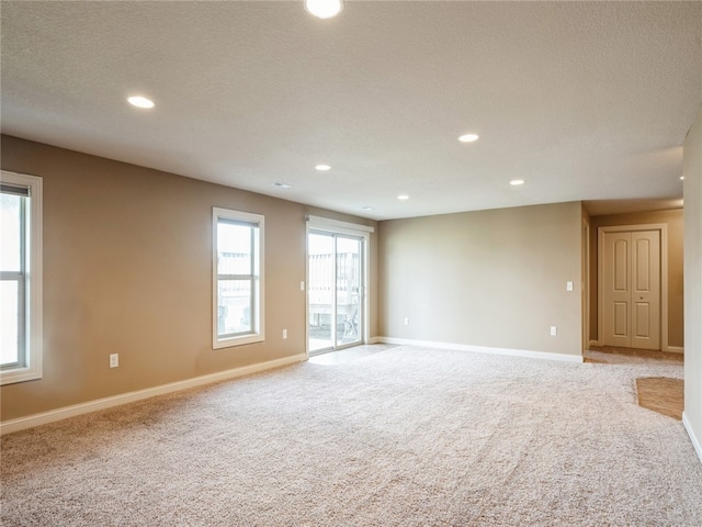 carpeted empty room featuring a textured ceiling