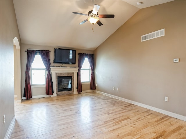 unfurnished living room with light hardwood / wood-style floors, vaulted ceiling, and a wealth of natural light