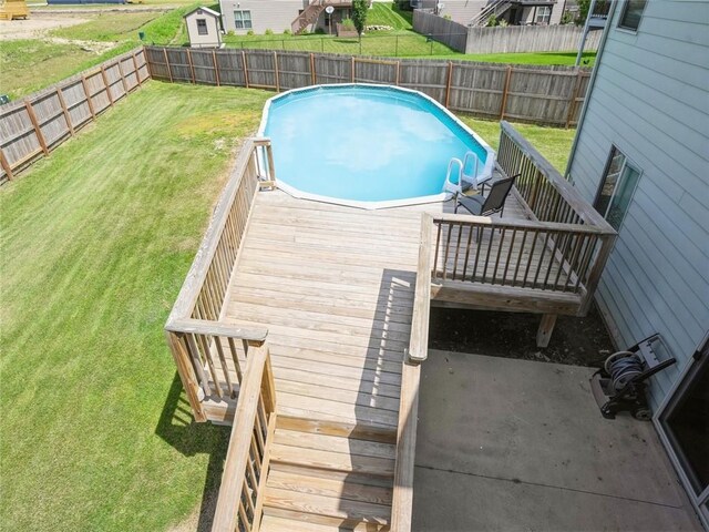 view of swimming pool featuring a yard and a wooden deck