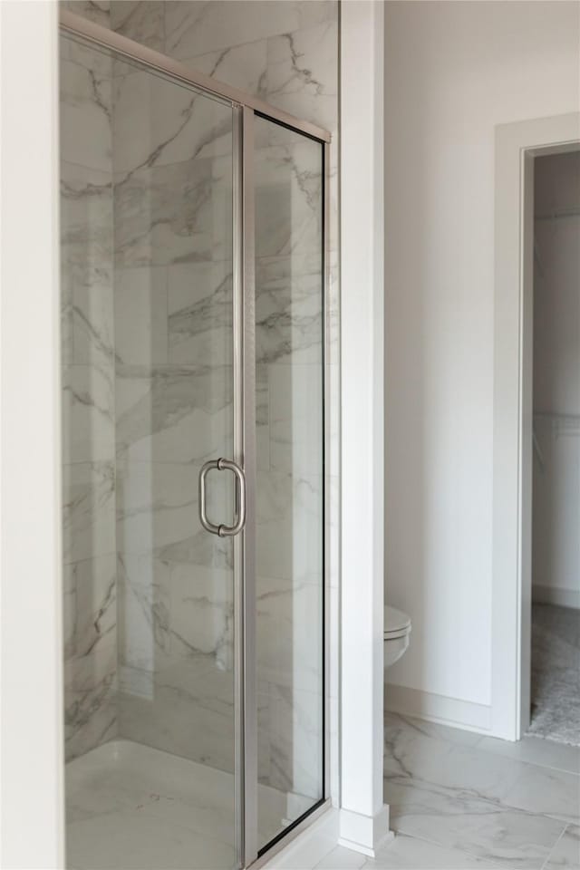 127 N 36th St, Cumming, IA 50061 - full bathroom featuring toilet, marble finish flooring, a marble finish shower, and baseboards