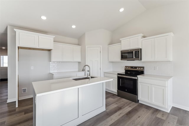 kitchen with stainless steel appliances, vaulted ceiling, decorative backsplash, and a sink