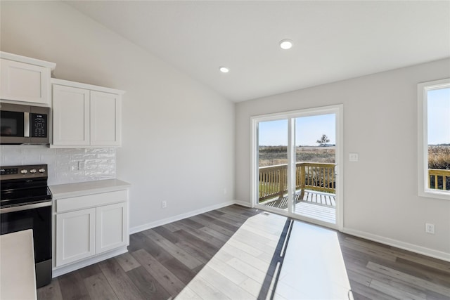 kitchen with dark wood-style flooring, stainless steel microwave, range with electric cooktop, and tasteful backsplash