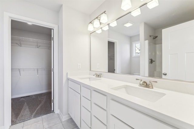 full bathroom with double vanity, a sink, marble finish floor, and a shower