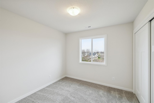 unfurnished bedroom with carpet and a closet