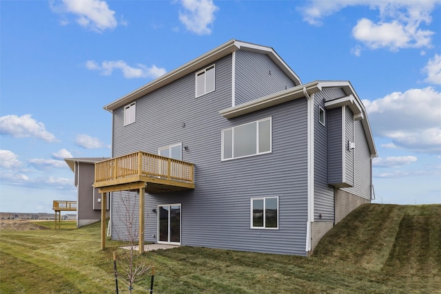 back of property featuring a yard and a wooden deck