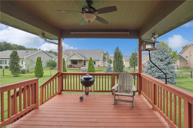 wooden terrace with ceiling fan and a yard