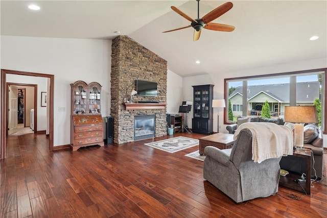 living room with dark hardwood / wood-style floors, ceiling fan, a fireplace, and vaulted ceiling