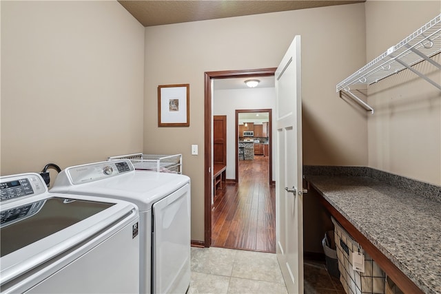 clothes washing area featuring washing machine and clothes dryer and light tile patterned floors