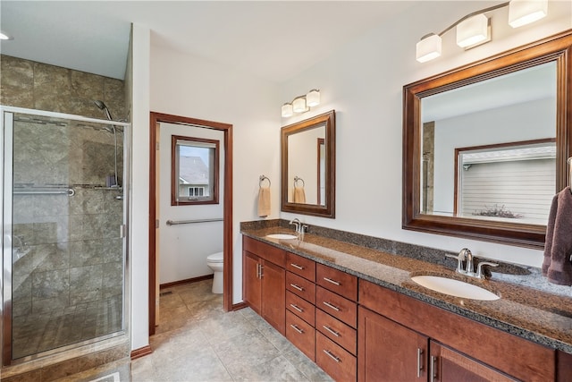 bathroom with tile patterned floors, vanity, toilet, and walk in shower