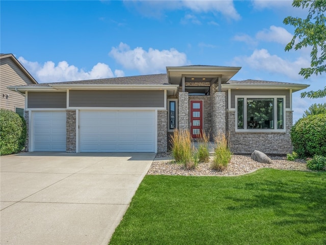 prairie-style home featuring a garage and a front lawn