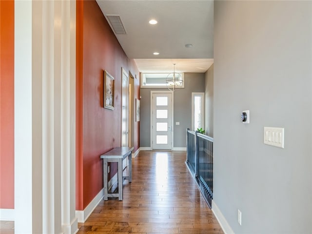 entrance foyer with a chandelier and wood-type flooring