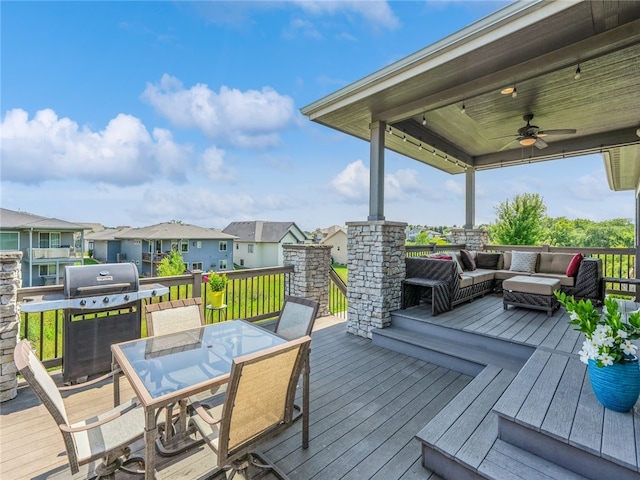 wooden deck with area for grilling, outdoor lounge area, and ceiling fan