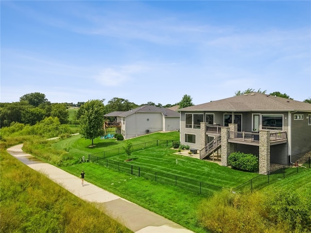 back of property with a lawn and a wooden deck