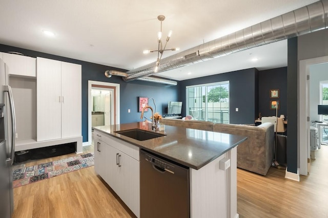 kitchen featuring pendant lighting, sink, dishwasher, white cabinetry, and a center island with sink