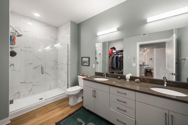 bathroom with vanity, hardwood / wood-style floors, a shower with shower door, and toilet