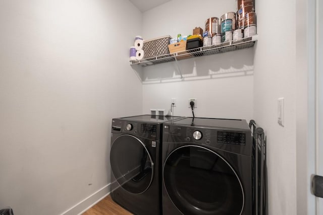 laundry room with hardwood / wood-style flooring and washer and clothes dryer