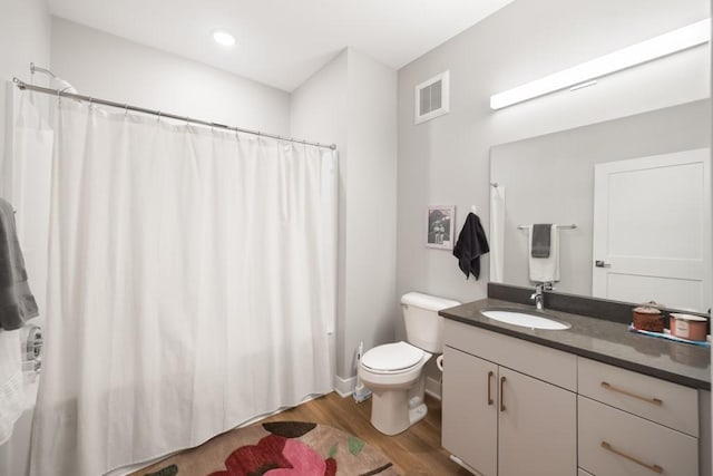 bathroom with wood-type flooring, vanity, and toilet