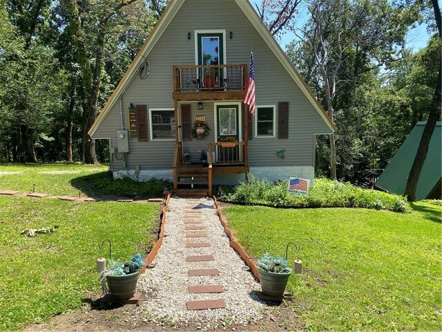 bungalow featuring a balcony and a front yard