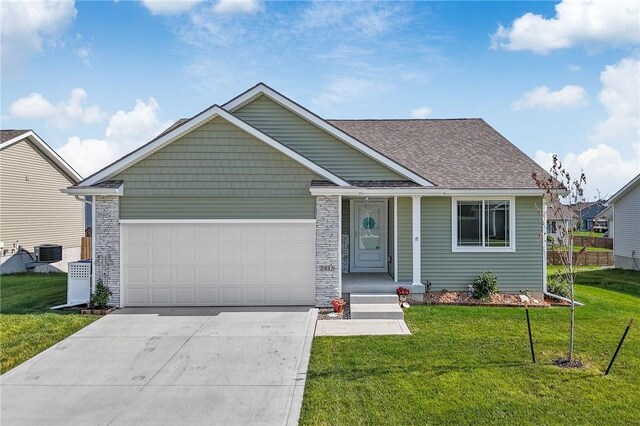 view of front of property featuring a garage, central AC, and a front lawn