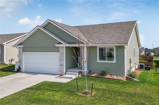 view of front of property featuring central air condition unit, a garage, and a front lawn