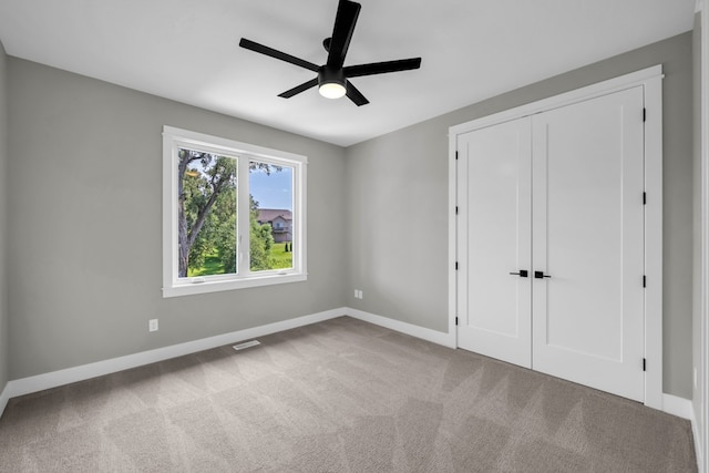 unfurnished bedroom featuring a closet, carpet flooring, and ceiling fan