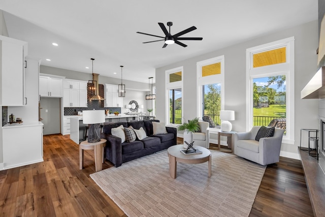 living room with ceiling fan, wood-type flooring, and a wealth of natural light