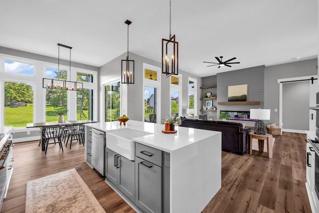 kitchen with gray cabinets, hardwood / wood-style flooring, ceiling fan, hanging light fixtures, and a center island