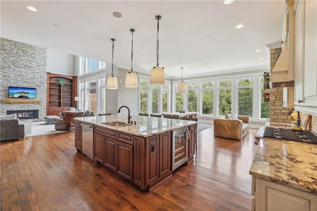 4701 150th St, Urbandale, IA 50323 - kitchen with a fireplace, beverage cooler, a sink, open floor plan, and dishwasher