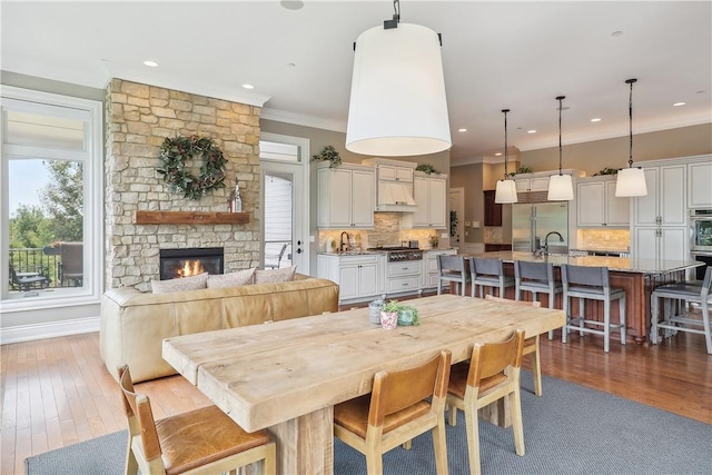 4701 150th St, Urbandale, IA 50323 - dining room featuring crown molding, hardwood / wood-style floors, a fireplace, and recessed lighting