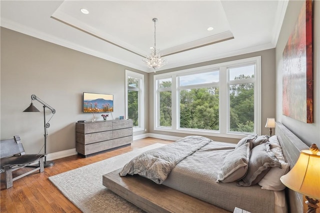 4701 150th St, Urbandale, IA 50323 - bedroom featuring a raised ceiling, multiple windows, a chandelier, wood finished floors, and crown molding