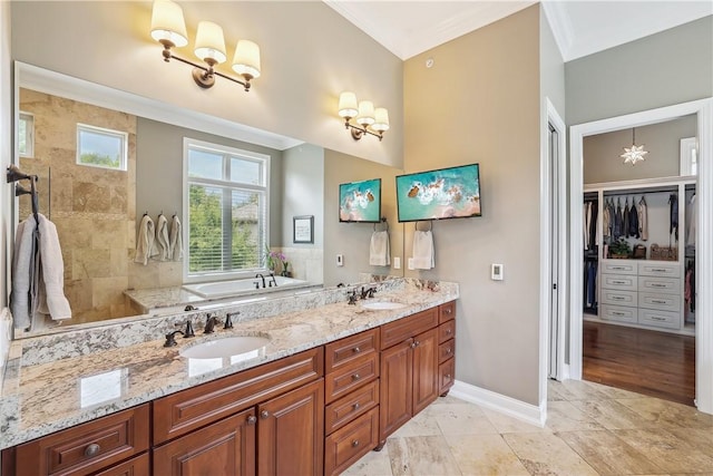 4701 150th St, Urbandale, IA 50323 - bathroom with a chandelier, ornamental molding, a bath, double vanity, and a walk in closet