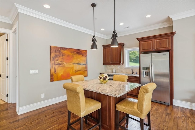 4701 150th St, Urbandale, IA 50323 - kitchen featuring stainless steel refrigerator with ice dispenser, dark wood finished floors, baseboards, a kitchen breakfast bar, and a kitchen island