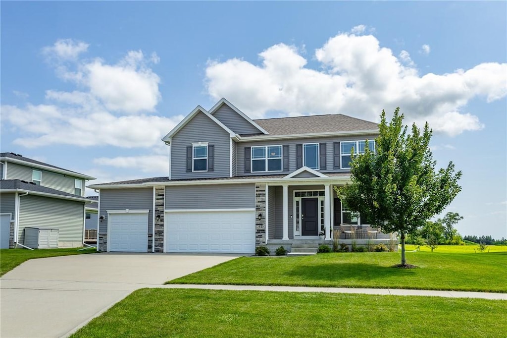 view of front of house featuring a front yard, a garage, and a porch