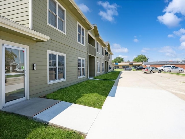 exterior space featuring a yard and uncovered parking