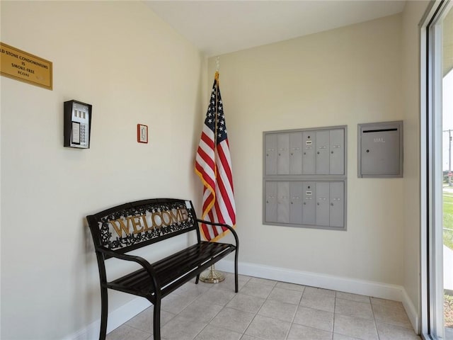 sitting room featuring light tile patterned flooring, mail area, and baseboards