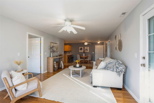 living room featuring light hardwood / wood-style floors and ceiling fan