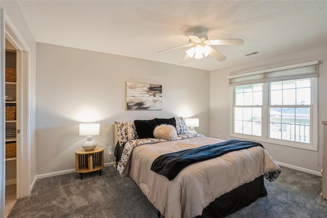 carpeted bedroom featuring visible vents, baseboards, and a ceiling fan