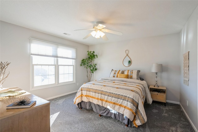 bedroom featuring visible vents, baseboards, a ceiling fan, and dark carpet