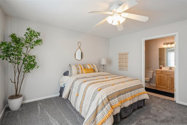 bedroom featuring baseboards, ensuite bath, and carpet