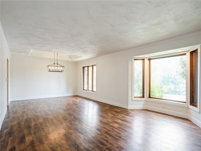 empty room with an inviting chandelier, a healthy amount of sunlight, and hardwood / wood-style floors