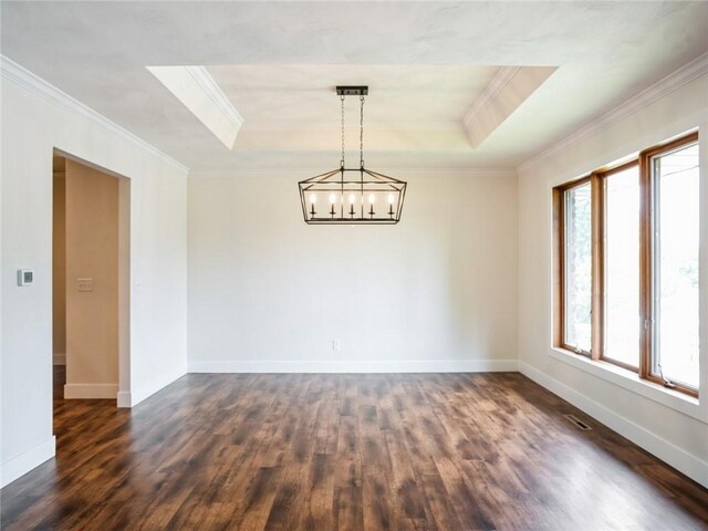 unfurnished room featuring crown molding, a healthy amount of sunlight, dark hardwood / wood-style flooring, and a tray ceiling