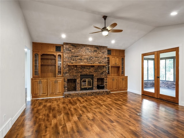 unfurnished living room with vaulted ceiling, a brick fireplace, ceiling fan, and dark hardwood / wood-style floors